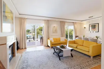 a living room with yellow furniture and a fireplace at Villa Sara in Quarteira