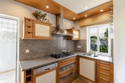 a kitchen with wooden cabinets and a counter top at Villa Sara in Quarteira