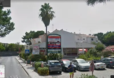 a parking lot with cars parked in front of a building at 2 Bed apartment with Roof Top Pool, close to Falesia Beach AT10 in Albufeira