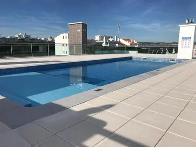 a swimming pool on the roof of a building at 2 Bed apartment with Roof Top Pool, close to Falesia Beach AT10 in Albufeira
