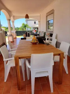 a dining room with a wooden table and white chairs at Villa Med - private pool, garden, sun all day, stunning views in Albufeira