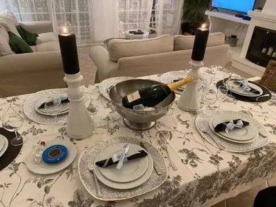 a table with plates and candles and a bottle of wine at Villa Med - private pool, garden, sun all day, stunning views in Albufeira
