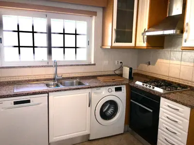 a kitchen with a sink and a washing machine at Villa Med - private pool, garden, sun all day, stunning views in Albufeira