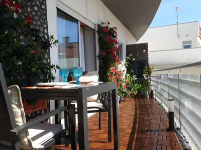 a table and chairs on a balcony with flowers at Mshomes II in Albufeira