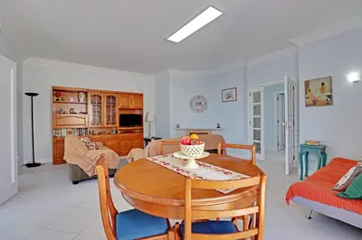 a living room with a table and a couch at Vilamoura Main Avenue by Homing in Vilamoura