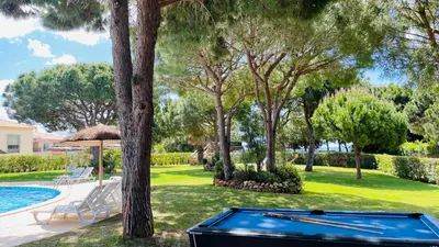 a pool table in front of a yard with trees at Bicos 303 by Check-in Portugal in Albufeira