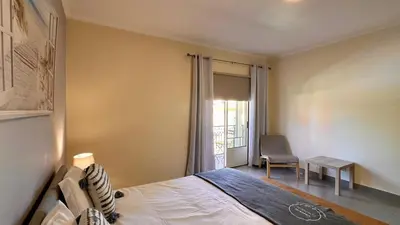 a bedroom with a bed and a chair and a window at Bicos 303 by Check-in Portugal in Albufeira