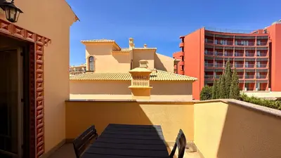 a balcony with a table and chairs and a building at Bicos 303 by Check-in Portugal in Albufeira