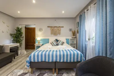 a bedroom with a bed and two chairs and a desk at Alcharb - Modern Studio - Vilamoura center in Vilamoura