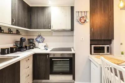 a kitchen with wooden cabinets and a stove top oven at Alcharb - Modern Studio - Vilamoura center in Vilamoura