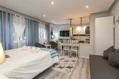 a hotel room with a bed and a kitchen at Alcharb - Modern Studio - Vilamoura center in Vilamoura