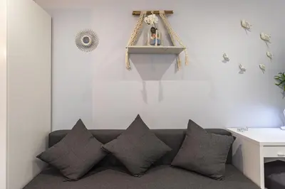 a living room with a couch with pillows at Alcharb - Modern Studio - Vilamoura center in Vilamoura