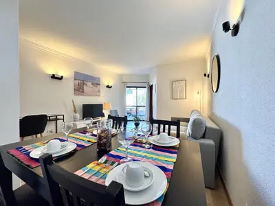 a dining room and living room with a table and chairs at Albufeira Salgados Beach 1 by Homing in Albufeira