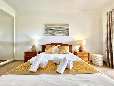 a bedroom with a large white bed with two lamps at Albufeira Salgados Beach 1 by Homing in Albufeira