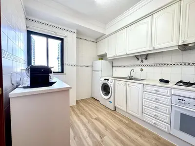 a kitchen with white cabinets and a washer and dryer at Albufeira Salgados Beach 1 by Homing in Albufeira