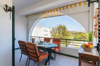 a patio with a table and chairs on a balcony at Albufeira Salgados Beach 1 by Homing in Albufeira