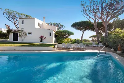 a villa with a swimming pool in front of a house at Casa Las Trinitarias in Vale do Lobo