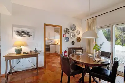 a kitchen and dining room with a table and chairs at Casa Las Trinitarias in Vale do Lobo