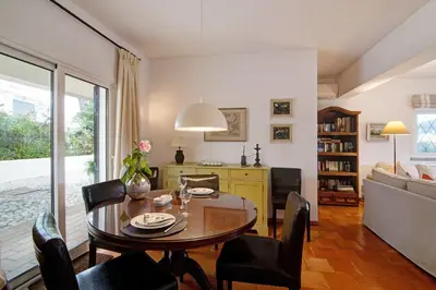 a living room with a table and a fireplace at Casa Las Trinitarias in Vale do Lobo