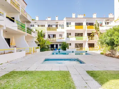 an apartment with a swimming pool in front of a building at AL - Apartamento Sunrise, Sol Nascente 1 Ground floor in Vilamoura