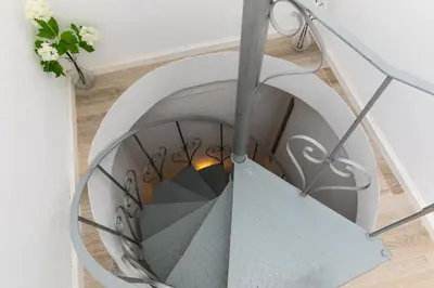 a spiral stairwell in a home with a spiral staircase at Typical Fisherman's Cottage with amazing sea views! in Albufeira