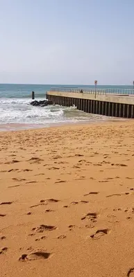 a beach with footprints in the sand and a pier at Sunset View Apartment - 22 in Albufeira