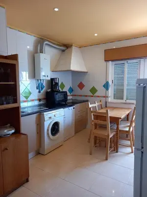 a kitchen with a table and a washing machine at Sunset View Apartment - 22 in Albufeira