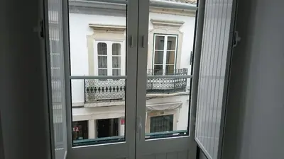 a window with a view of a building at Faro City Center Apartment I in Faro