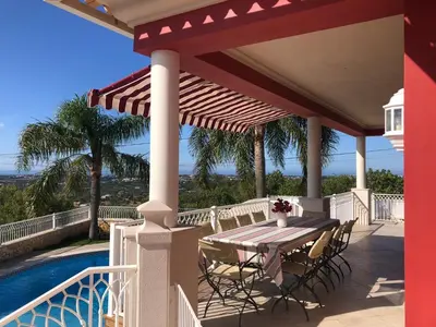 a patio with a table and chairs next to a pool at CASA PANORAMICA VUE MER 8 a 10 Personnes in Boliqueime