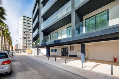 a building with a car parked in front of it at Apartamento Porlamar in Quarteira