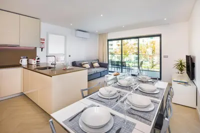 a kitchen and a dining room with a table and chairs at Apartamento Porlamar in Quarteira