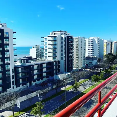 a view of a city with tall buildings and the ocean at Castelo I in Quarteira