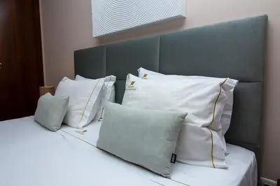a bed with a blue headboard with pillows on it at Herdade dos Salgados Beach Apartment Dalma Delux in Albufeira