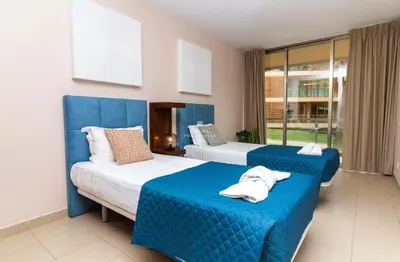 two beds in a room with blue and white at Herdade dos Salgados Beach Apartment Dalma Delux in Albufeira