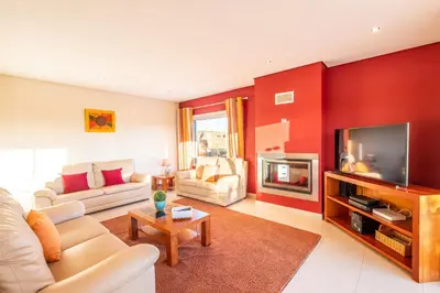 a living room with a couch and a tv at Villa Cordeiro - Heated Pool - Free wi-fi - Air Con in Guia