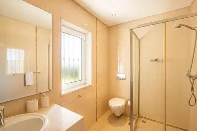 a bathroom with a shower and a toilet and a sink at Villa Cordeiro - Heated Pool - Free wi-fi - Air Con in Guia
