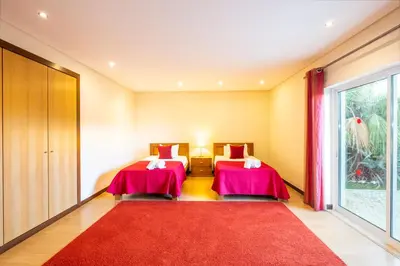 two beds in a room with a red rug at Villa Cordeiro - Heated Pool - Free wi-fi - Air Con in Guia