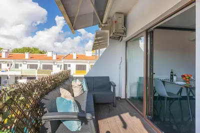 a patio with a couch and a table on a balcony at Vilamoura Premium Apartment With Pool by Homing in Vilamoura