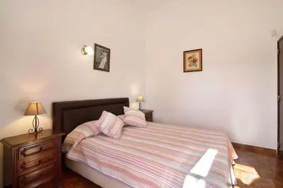 a bedroom with a bed with pink and white stripes at Vila Caracol in Guia