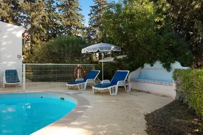 a patio with chairs and an umbrella next to a pool at Vila Filipa in Guia