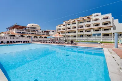 a table with candles and wine glasses on a balcony at Apartment Vista Mar Piscina Albufeira in Albufeira