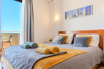 a bedroom with a bed and a balcony with the ocean at Apartment Vista Mar Piscina Albufeira in Albufeira