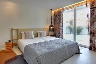 a bedroom with a large bed and a large window at Casa do Pátio-Two Private Pools Villa- Rooftop & Panoramic Pool by DreamvillasAlbufeira in Albufeira
