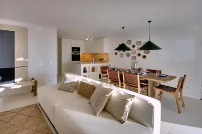 a living room and kitchen with a white couch and a table at Casa do Pátio-Two Private Pools Villa- Rooftop & Panoramic Pool by DreamvillasAlbufeira in Albufeira
