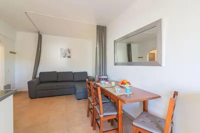 a living room with a table and a couch at Vilamoura Cosy 2 with Pool by Homing in Vilamoura