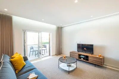 a living room with a blue couch and a tv at Apartment Melbourne 1 by Algarve Vacation in Albufeira