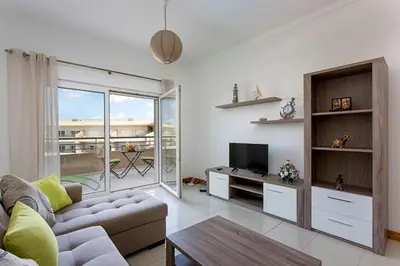a living room with a couch and a tv at Albufeira - Apartment - Sleeps 4 - Pool - Seaside in Albufeira