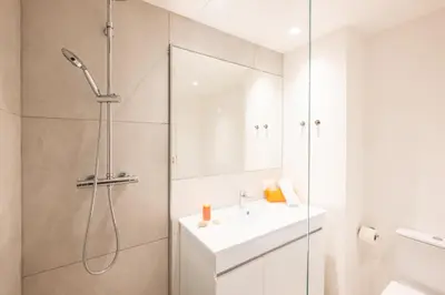 a white bathroom with a shower and a sink at Apartment Melbourne 2 by Algarve Vacation in Albufeira