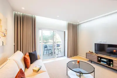 a living room with a couch and a tv and a table at Apartment Melbourne 2 by Algarve Vacation in Albufeira
