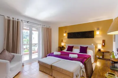 a bedroom with a bed and a table at Varandas Do Lago Villa in Almancil